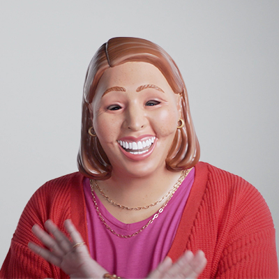 Photo of a woman wearing a red cardigan, pink top and wearing a mask