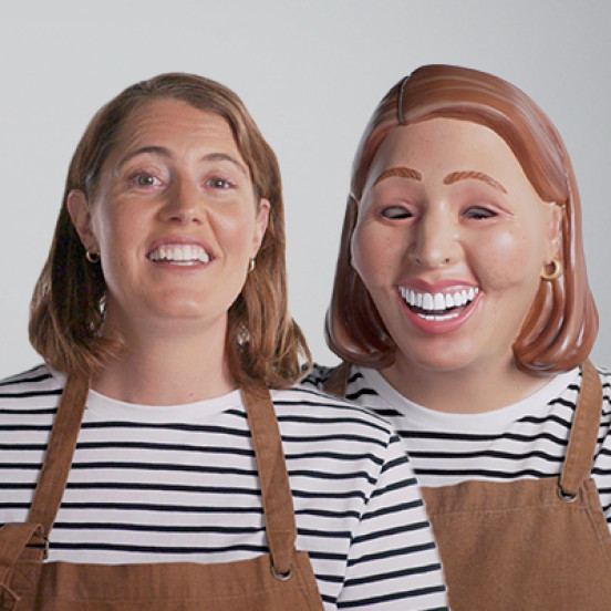 Photo of a woman wearing an apron with another woman next to her that is dressed the same but wearing a mask